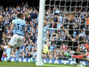 Manchester City's David Silva, centre, scores his side's first goal during the English Premier League soccer match between Manchester City and Swansea City at Etihad stadium in Manchester, England, Sunday, April 22, 2018.