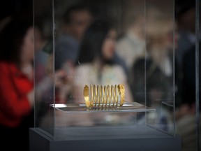 An ancient Dacian gold bracelet is displayed during a press conference at the national history museum in Bucharest, Romania, Thursday, April 19, 2018. A treasure trove of coins and bracelets from the 1st century that were stolen from archeological sites in western Romania and illegally smuggled out of the country has been put on display after being recovered in Austria during a cross-border investigation.