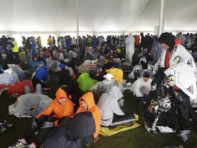 Athletes wait under a tent at the athlete's village for the start of the the 122nd Boston Marathon on Monday, April 16, 2018, in Hopkinton, Mass.