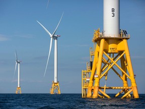 FILE - In this Aug. 15, 2016, file photo, three of Deepwater Wind's turbines stand in the water off Block Island, R.I. Using federal offshore leases, wind power projects along the East Coast are pressing ahead in 2018, with the goal of transforming the electric grid and providing energy to power millions of homes.