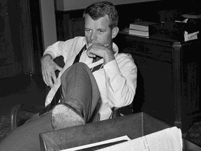 FILE - In this May 21, 1961, file photo, U.S. Attorney General Robert F. Kennedy, brother of President John F. Kennedy, rests his foot on a desk at the Justice Department, in Washington, D.C., while working with aides considering legal measures to be taken following racial violence, in Montgomery, Ala. Nearly 50 years after Robert F. Kennedy's assassination, a new documentary series on his life and transformation into a liberal hero is coming to Netflix. "Bobby Kennedy for President" produced by RadicalMedia, Trilogy Films and LooksFilm launches Friday, April 27, 2018, on Netflix.