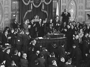 FILE - In this April 22, 1965 file photo, Dr. Martin Luther King Jr., center, receives applause after finishing a speech to the joint session of the Massachusetts Legislature in Boston, the day before he led a civil rights march to Boston Common. King's final speech before his 1968 assassination will be read aloud 50 years later on Monday, April 2, 2018, in downtown Boston.