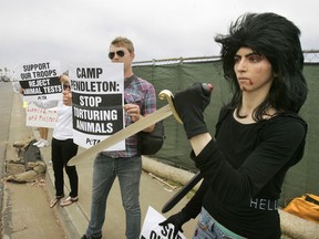 This Aug. 12, 2009, photo shows Nasim Aghdam, right, as she joins members of People for the Ethical for Animals, PETA, protesting at the main gate of Marine Corps base Camp Pendleton in Oceanside, Calif., against the Marine's killings of pigs in a military exercise. Law enforcement officials have identified Nasim Aghdam as the person who opened fire with a handgun Tuesday, April 3, 2018, at YouTube headquarters in San Bruno, Calif., wounding several people before fatally shooting herself.