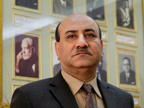 FILE -- In this April 16, 2014 file photo, Hesham Genena, then head of Egypt's oversight body, poses for a portrait in front of pictures of his predecessors at his office in Cairo, Egypt. A defense lawyer says a military court on Tuesday, April 24, 2018 has convicted Egypt's former anti-graft chief of insulting the armed forces and sentenced him to five years in prison.