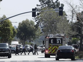 Officers walk near a YouTube office in San Bruno, Calif., Tuesday, April 3, 2018. Police in Northern California are responding to reports of a shooting at YouTube headquarters in the city of San Bruno.