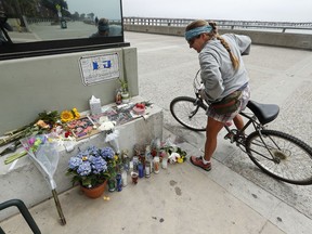 In this Monday, April 23, 2018 photo, Alicia Carman, of Ventura, looks at a memorial outside of Aloha Steakhouse on the Promenade in Ventura, Calif., where Anthony Mele Jr., 35, was stabbed to death by a homeless man as he was having dinner with his wife and five-year-old daughter. (Mel Melcon/Los Angeles Times via AP