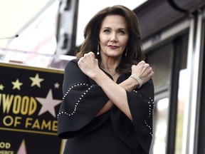 Lynda Carter crosses her arms in a Wonder Woman pose at a ceremony honoring her with a star on the Hollywood Walk of Fame on Tuesday, April 3, 2018, in Los Angeles.
