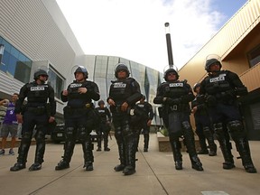 FILE - In this March 29, 2018, file photo, helmet-clad Sacramento Police officers stand near the entrance to the Golden 1 Center, before the Sacramento Kings host the Indiana Pacers in an NBA basketball game, in Sacramento, Calif. Recent demonstrations held outside the arena against the police shooting of Stephon Clark, who was unarmed, caused the lockdown of the building leaving thousands of ticket holders unable to attend some recent games. Sacramento Police Chief Daniel Hahn, the city's first black police chief, is an unlikely officer, growing up in a tough neighborhood of California's capital city and having his own early run-ins with police. He is struggling to find the right balance of reforms after the fatal shooting of Clark by his officers.
