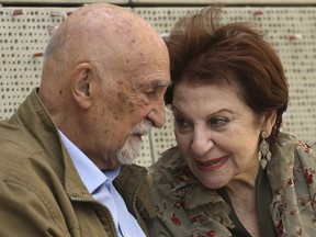 In this Wednesday, April 11, 2018, photo, childhood Holocaust survivors Simon Gronowski and Alice Gerstel Weit talk as they are interviewed at the Los Angeles Holocaust Museum, after their reunion after more than 70 years. There was much hugging, kissing and crying Wednesday as the two old friends held hands tightly while sitting outside on a museum patio to share memories from a long-ago past.