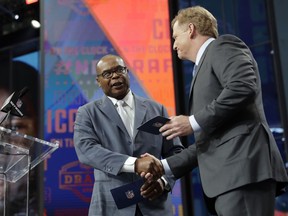 Prof Football Hall of Famer Mike Singletary, left, greets NFL Commissioner Roger Goodell as Singletary announces the Chicago Bears' pick during the second round of the NFL football draft Friday, April 27, 2018, in Arlington, Texas. The Bears selected Iowa's James Daniels.