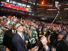 Southern California's Sam Darnold takes a selfie as he poses with fans after being elected by the New York Jets during the first round of the NFL football draft Thursday, April 26, 2018, in Arlington, Texas.