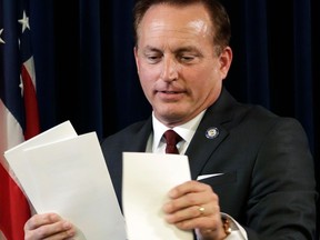 FILE - In this Dec. 19, 2016, file photo, Iowa Secretary of State Paul Pate collects ballots during Iowa's Electoral College vote at the Statehouse in Des Moines. Pate did not disclose his role in a newly-formed company that has spent around $2 million opening a self-storage rental business and purchasing a strip mall, according to a review by The Associated Press.