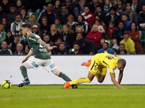 Saint-Etienne's Mathieu Debuchy, left, challenges for the ball with PSG's Kylian Mbappe Lottin, right, during the French League One soccer match between Saint-Etienne and Paris Saint Germain, in Saint-Etienne, central France, Friday, April 6, 2018.