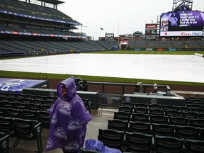 Wrapped in a poncho, a lone guard waits amid the empty seats during a weather delay to the start of a baseball game between the San Diego Padres and Colorado Rockies Tuesday, April 24, 2018, in Denver.