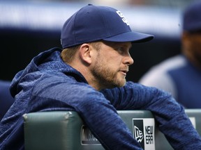 San Diego Padres manager Andy Green hangs over the dugout rail as he looks on against the Colorado Rockies in the first inning of a baseball game Tuesday, April 10, 2018, in Denver.