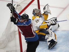 Nashville Predators goaltender Pekka Rinne, back, drops to the ice after missing a shot off the stick of Colorado Avalanche left wing Blake Comeau for a goal in the first period of Game 3 of an NHL hockey first-round playoff series Monday, April 16, 2018, in Denver.