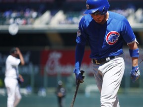 Chicago Cubs' Kris Bryant, right, turns away from the batter's box after getting hit in the helmet by a pitch from Colorado Rockies starter German Marquez, back left, in the first inning of a baseball game Sunday, April 22, 2018, in Denver. Bryant was forced to leave the game.