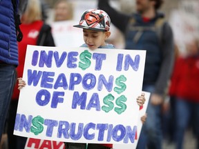 Tiago Gayosso, a student of Jefferson County, Colo., schools in Edgewater, Colo., carries a sign as he marches around the State Capitol during a teacher rally Thursday, April 26, 2018, in Denver. More than 10,000 teachers in Colorado are expected to demonstrate as part of a burgeoning teacher uprising from the East to the interior West that is demanding more tax dollars be spent in public schools.