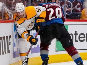 Nashville Predators left wing Austin Watson (51) slips past Colorado Avalanche center Nathan MacKinnon (29) during the second period in Game 6 of an NHL hockey first-round playoff series Sunday, April 22, 2018, in Denver.