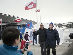 Siumut party candidate Karl Kristian Kruse, left, and leader of the Siumut Party Kim Kielsen pose for photographs outside Godthaabshallen on election day in Nuuk, Greenland, Tuesday, April 24, 2018. Greenlanders were voting on Tuesday to elect all 31 members of Parliament.