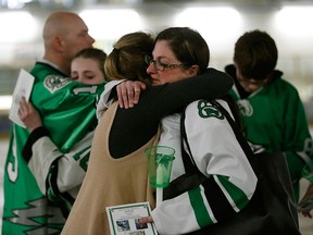 Cory Anne Holmlund, right, is hugged during a vigil for Humboldt Broncos hockey player Parker Tobin in Drayton Valley, Alta., on April 10, 2018. She was Parker Tobin's billet mother.