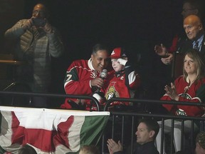 Canadians Consul General Khawar Nasim, center left, and Jonathan Pitre, right, help with the call out the "Let's Play Hockey" arena tradition prior to the start of an NHL hockey game with the Minnesota Wild against Ottawa Senators, Thursday, March 30, 2017, in St. Paul, Minn. The mother of an Ottawa-area teen with a rare and painful skin condition says her son, who worked tirelessly to raise awareness about the disease, has died.