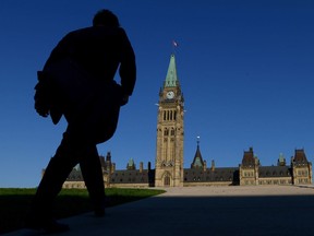 A man walks on Parliament Hill on September 15, 2014. A federal grant for parents of murdered and abducted children may be inadvertently missing out on providing financial help to those "more vulnerable economically," a newly released report says. The federal evaluation made public today cautions against drawing any hard conclusions from the numbers, given how few parents have applied for, and received the grant since it launched in January 2013.