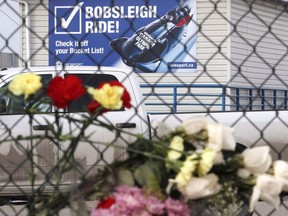 Flowers are placed on a fence near the start area for the bobsled track after an incident on the track that left two teenagers dead and six injured at Canada Olympic Park in Calgary on February 7, 2016. One of the survivors of a deadly slide down the bobsled run at Canadian Olympic Park in Calgary says fences or signs probably wouldn't have stopped him that night.THE CANADIAN PRESS/Larry MacDougal