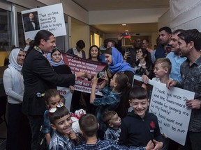 Liberal MP Robert-Falcon Ouellette, left, greets mother Nofa Mihlo Rafo as friends and family are reunited with 12-year-old Emad Mishko Tamo, third from right, in Winnipeg on August 17, 2017. Canada should increase its refugee resettlement targets and offer more robust and integrated settlement services to vulnerable groups, a commons committee has recommended. The federal Standing Committee on Citizenship and Immigration delivered its report last week on a study it conducted looking at resettlement issues faced by Yazidi women and children in Canada.