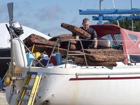 A Canada Border Services Agency officer inspects the sailboat Quesera at East River Marine in Hubbards, N.S., on Friday, Sept. 8, 2017. The sentencing of a sailboat captain who smuggled drugs into Nova Scotia from a small Caribbean island has been delayed yet again, this time for the Crown to call an expert witness.