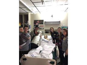 Ryan Straschnitzki, centre, poses with brothers Connor, left to right, and Jett, father Tom, girlfriend Erica, sister Jaden and mother Michelle as they pose with the Stanley Cup at Royal University Hospital in Saskatoon in this recent handout photo. One of the Humboldt Broncos players who was injured in this month's bus crash has been transferred to Foothills Hospital in Calgary.
