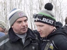 Humboldt Broncos assistant coach Chris Beaudry, right, embraces Adam Herold's father Russ as family and friends celebrate what would have been Adam's 17th birthday in Montmartre, Sask. on Thursday, April 12, 2018. The family of one of the players killed in the Humboldt Broncos bus crash wants the Saskatchewan government to improve safety at highway intersections and to make the work a priority.