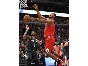 Chicago Bulls' Cristiano Felicio (6), of Brazil, battles Brooklyn Nets' D'Angelo Russell (1) for the ball during the first half of an NBA basketball game Saturday, April 7, 2018, in Chicago.