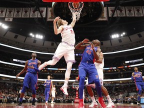 Chicago Bulls forward Lauri Markkanen (24) tips the ball in past Detroit Pistons forward Anthony Tolliver (43) during the first half of an NBA basketball game in Chicago, Wednesday, April 11, 2018.