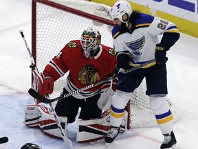 Chicago Blackhawks goalie J-F Berube, left, blocks a shot by St. Louis Blues right wing Chris Thorburn during the first period of an NHL hockey game Friday, April 6, 2018, in Chicago.