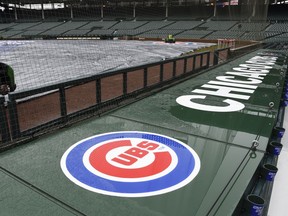 The tarp lays on Wrigley Field after a baseball game between the Atlanta Braves and the Chicago Cubs was postponed on Sunday, April 15, 2018, in Chicago. The game is rescheduled for Monday May 14, 2018.
