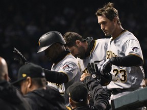 Pittsburgh Pirates' Gregory Polanco, left, and David Freese (23) celebrate with teammates after they scored during the second inning of a baseball game against the Chicago Cubs on Wednesday, April 11, 2018, in Chicago.