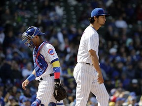 Chicago Cubs starting pitcher Yu Darvish, right, of Japan, and catcher Willson Contreras react after talking to each other on the field during the fifth inning of a baseball game against the Milwaukee Brewers, Friday, April 27, 2018, in Chicago.