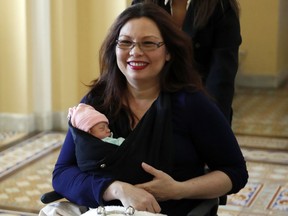 Sen. Tammy Duckworth, D-Ill., carries her baby Maile Pearl Bowlsbey after they went to the Senate floor to vote, on Capitol Hill, Thursday, April 19, 2018 in Washington.