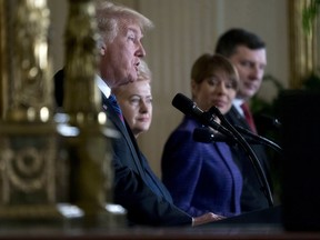 From left, President Donald Trump, accompanied by Lithuanian President Dalia Grybauskaite, Estonian President Kersti Kaljulaid and Latvian President Raimonds Vejonis, seen in reflection, speaks at a news conference in the East Room of the White House in Washington, Tuesday, April 3, 2018.