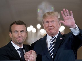 President Donald Trump and French President Emmanuel Macron embrace at the end of a news conference in the East Room of the White House in Washington, Tuesday, April 24, 2018.