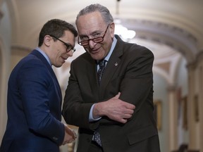 Senate Minority Leader Chuck Schumer, D-N.Y., confers with his communications aide Matt House as he speaks to reporters following a closed-door strategy session on Capitol Hill in Washington, Tuesday, April 17, 2018.