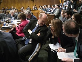 Amid President Donald Trump's repeated criticism of special counsel Robert Mueller's Russia investigation, Sen. Chris Coons, D-Del., center, confers with his staff as the Senate Judiciary Committee works on a bipartisan bill to protect the special counsel should Trump try to fire him, on Capitol Hill in Washington, Thursday, April 26, 2018. The Special Counsel Independence and Integrity Act passed 14-7 but Senate Majority Leader Mitch McConnell has insisted he will not hold a full Senate vote on the legislation.