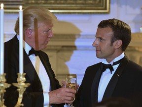 President Donald Trump, left, and French President Emmanuel Macron, right, share a toast during the State Dinner at the White House in Washington, Tuesday, April 24, 2018.