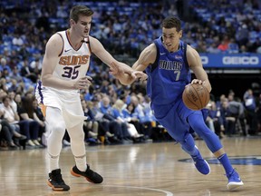 Phoenix Suns forward Dragan Bender (35) defends as Dallas Mavericks' Dwight Powell (7) drives to the basket in the first half of a NBA basketball game in Dallas, Tuesday, April 10, 2018.