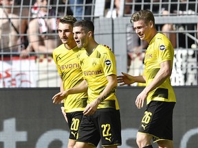 Dortmund's Christian Pulisic, center, reacts surprised after scoring during the German Bundesliga soccer match between Borussia Dortmund and VfB Stuttgart in Dortmund, Germany, Sunday, April 8, 2018.