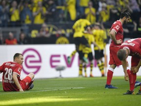 Stuttgart's Holger Badstuber is on the ground disappointed after they received the third goal during the German Bundesliga soccer match between Borussia Dortmund and VfB Stuttgart in Dortmund, Germany, Sunday, April 8, 2018.