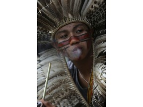 A Funio indigenous youth smokes a pipe at a camp coined "Free Land," during an annual gathering by Brazil's indigenous peoples in Brasilia, Brazil, Monday, April 23, 2018. Hundreds of indigenous Brazilians are setting up camp in the nation's capital for a week of speeches, protests and celebrations as they lobby the government to protect their rights.