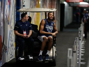 Villanova's Mikal Bridges rides on a cart as he leaves a news conference for the championship game of the Final Four NCAA college basketball tournament against Michigan, Sunday, April 1, 2018, in San Antonio.