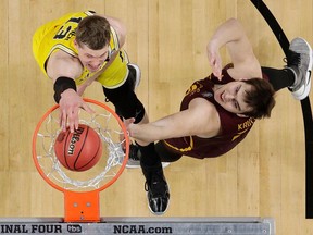 Michigan's Moritz Wagner (13) dunks over Loyola-Chicago's Cameron Krutwig (25) during the first half in the semifinals of the Final Four NCAA college basketball tournament, Saturday, March 31, 2018, in San Antonio.